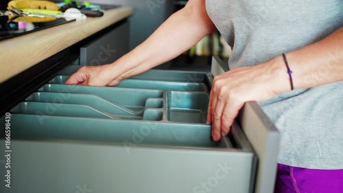 Hands preparing food in a kitchen with tools for cooking and a fresh item in hand