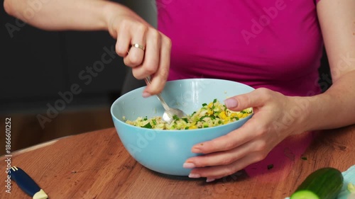 Mixing a fresh salad with vibrant ingredients at home in a cozy kitchen