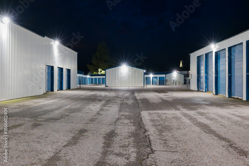 Evening view of a large illuminated self storage facility offering individual units for rent.