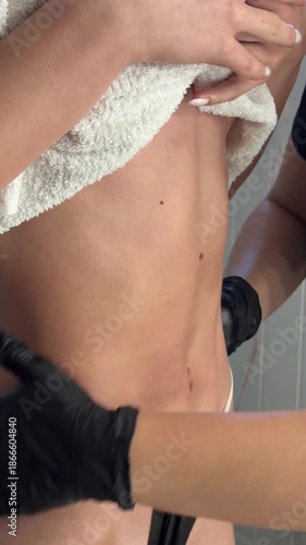 Close-up view of gloved hands massaging woman’s abdomen with oil in a wellness session