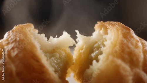 Golden Delights: A close-up showcases a freshly baked pastry split in two, revealing a fluffy interior, a sensory experience of flavor, texture, and the warmth of a culinary creation.