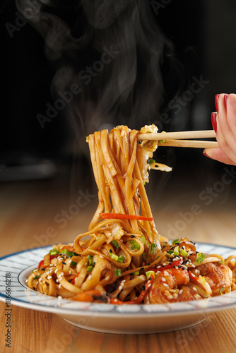 Delicious noodle dish with vegetables served on a plate in a cozy setting