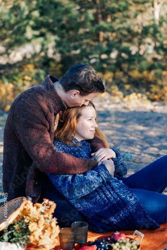 Portrait happy beautiful couple in love enjoying autumn picnic in autumn park. Vertical photo. High quality photo