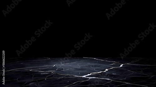 Cracked black marble surface with a subtle sheen and light reflections, evoking a sense of depth and texture