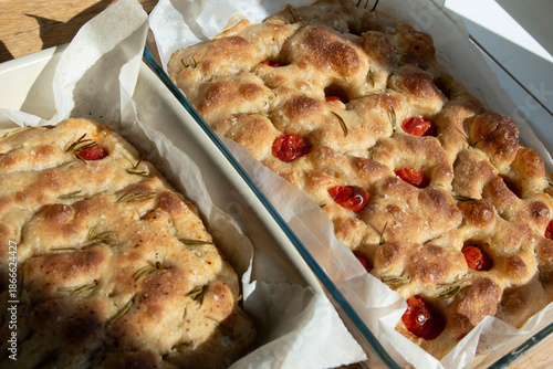 Freshly baked home made sourdough focaccia with cherry tomatoes and rosemary shot form above