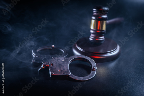 Wallpaper Mural Handcuffs and gavel on a dark surface, surrounded by smoke, symbolizing law enforcement, justice, and the legal system in a dramatic and evocative composition Torontodigital.ca