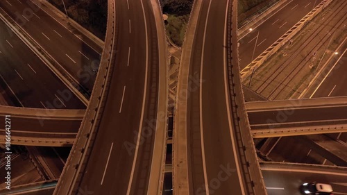 Aerial drone top down night video of urban elevated toll road junction and interchange overpass in rush hour