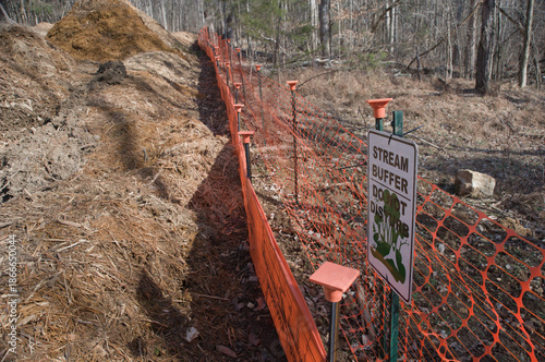 Fotografija Sign and geofencing mark a stream buffer area for erosion control in a wooded re