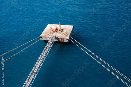 Bilde på lerret Concrete platform with mooring post and long ropes holding large boat in place