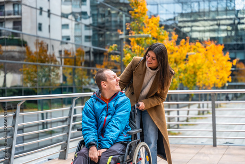 Caregiver pushing man in wheelchair during city outing