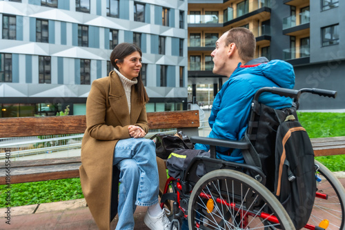 Fotografía Woman talking with disabled man in wheelchair outdoors