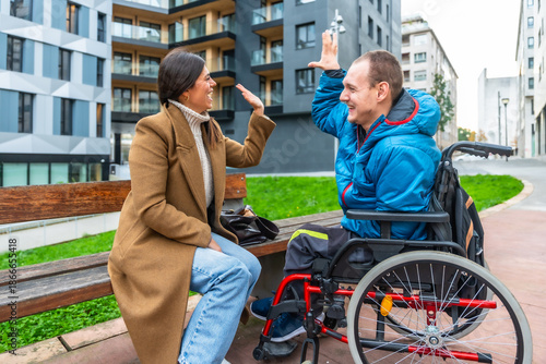 Billede på lærred Man with disability giving high five to female caregiver