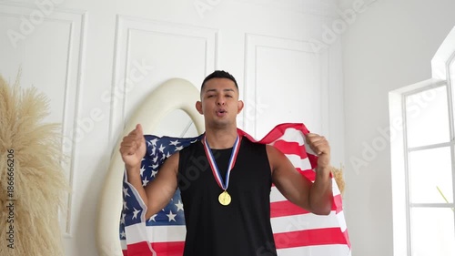 Young athlete celebrating with a medal and the US flag draped over his back
