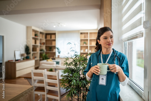 Φωτογραφία Healthcare professional enjoying coffee break by window at home