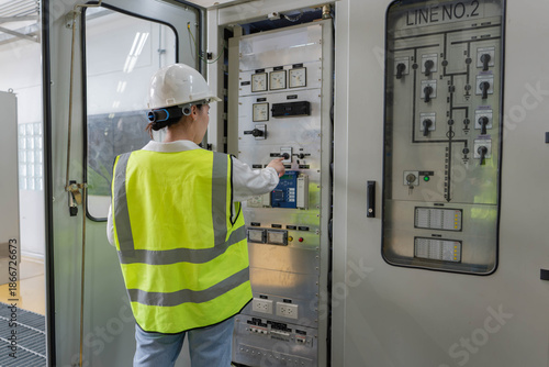 Bilde på lerret Technician operating electrical control panel inside power facility, performing