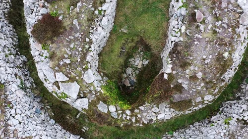 Carn Gluze aka Ballowall Barrow. St. Just, Cornwall. Bronze Age prehistoric funerary cairn chambered tomb mound and multiple stone cists. Altered by modern reconstruction. Aerial video fly up from cen