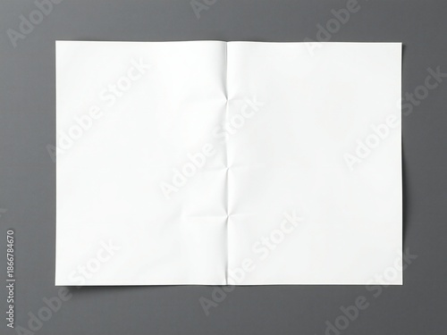 Crinkled white paper folded in half on a dark gray background
