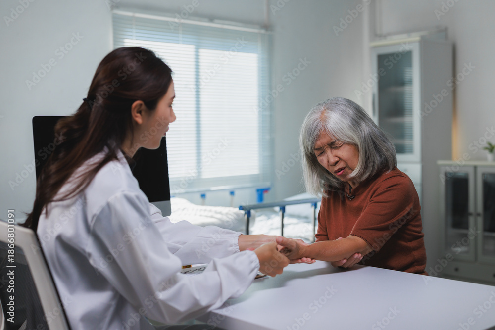 Fototapeta premium Doctor examining senior woman experiencing arm pain