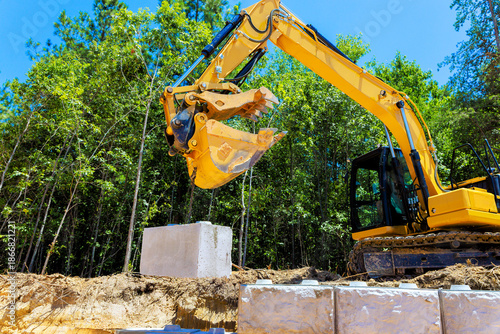 Excavator lifting concrete blocks at build sturdy retaining wall