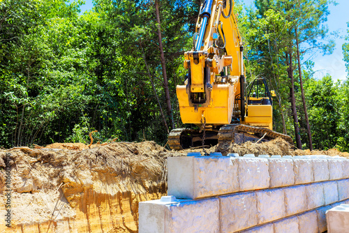 Excavator working on construction site creating retaining wall