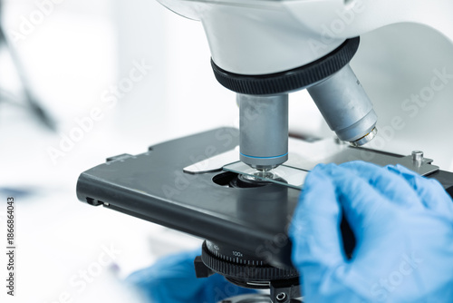 Billede på lærred Asian women scientist looking to microscope eyepiece from CBC hematology slide in clinical laboratory