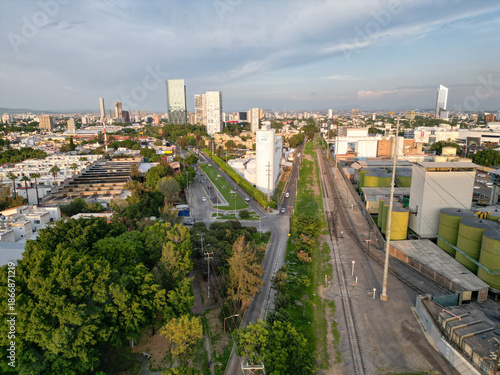 Horizontal drone photo of major road intersection in Guadalajara, with train tracks and industrial buildings