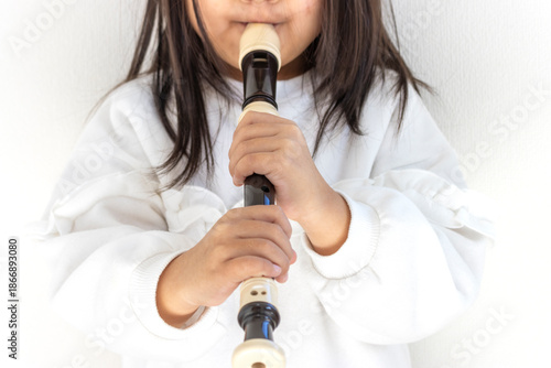 5歳の女の子がリコーダーを吹く（顔無し、日本人）