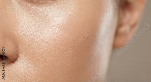 Close-up of smooth, radiant skin on a person's face, showcasing a healthy glow and even complexion. Emphasizing hydration and natural beauty in detail