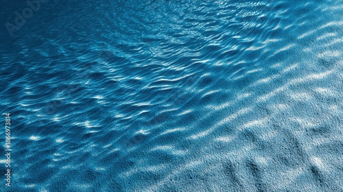 Abstract background with water ripples and sand, in a blue color, from a top-down view, suitable for a banner or summer vacation concept.