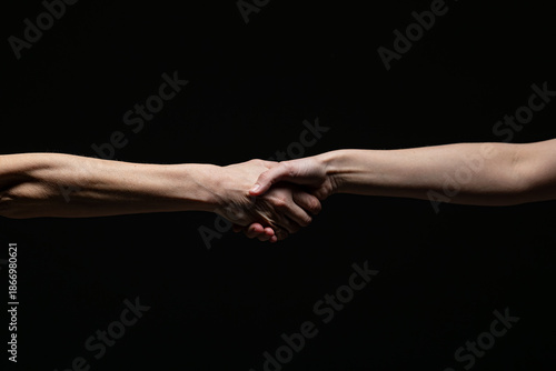Wallpaper Mural Two hands engage in a strong handshake, symbolizing agreement, trust, or partnership, against a black background with a high-contrast minimalist style Torontodigital.ca