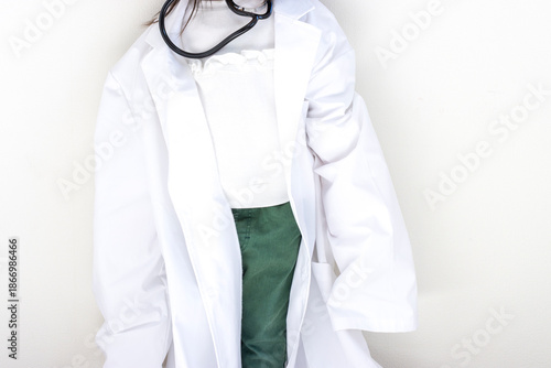 大人用の大きな白衣を羽織り、聴診器を持つ5歳の女の子（日本人、顔無し）