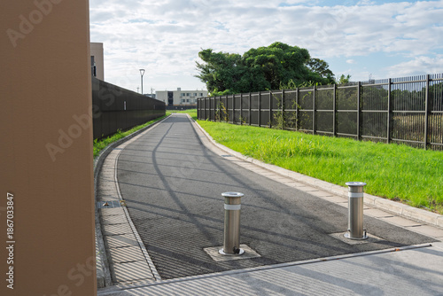 水道施設内の舗装された管理用道路と上下可動式の金属製車止めポール