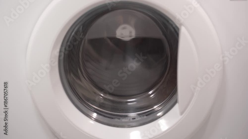 Foamy soap suds churning around shoes in washing machine drum, creating dynamic bubble patterns. Dense white foam envelops footwear during intense cleaning cycle.