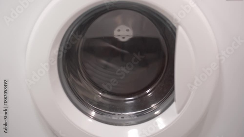 Foamy soap suds churning around shoes in washing machine drum, creating dynamic bubble patterns. Dense white foam envelops footwear during intense cleaning cycle.