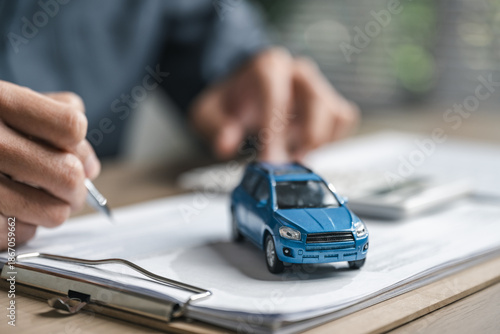 Car purchase concept with contract signing, showing vehicle agreement, insurance coverage, auto loan planning, and financial responsibility during dealership buying and ownership transfer.