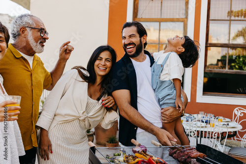 Fotografie Happy family enjoying a Brazilian churrasco together outdoors
