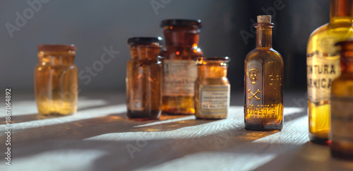 Fotografia Poison bottle with skull and bones stands among pharmaceutical bottles