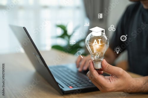 AI education and innovative learning concept. A hand holding a light bulb with AI symbol and graduation cap, featuring digital technology icons on a laptop for smart online training