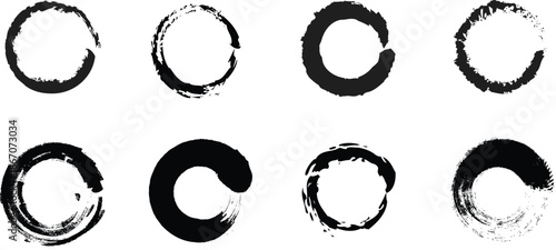 Abstract black ink brush stroke circles and round frames on white.