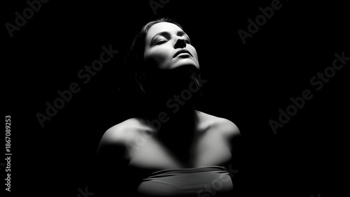 A woman in dramatic black and white portrait with mysterious expression