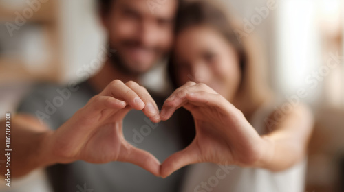 Romantic couple creating heart shape with hands
