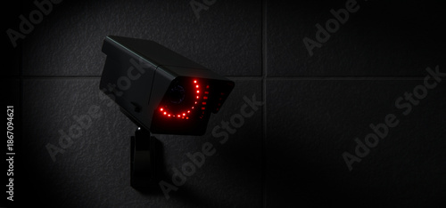 Black CCTV Security Camera with Red LED Lights on Dark Wall