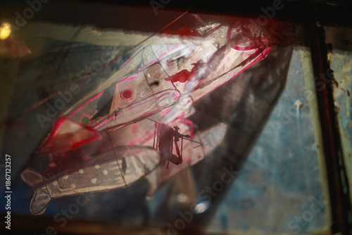 Tattered bamboo paper airplane under lights in 1980s Hong Kong.