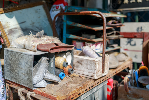 Close-up of a tailor and shoe repair stall in 1980s Hong Kong