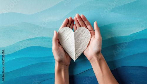 Mental health awareness concept hand paper heart human hand blue background ocean wave hope support empathy care wellness mental health awareness peace serenity calm kindness healing therapy