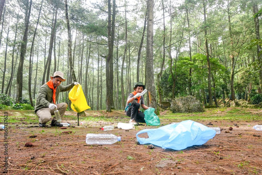 Fototapeta premium Dedicated Volunteers Cleaning up Plastic Waste in Lush Forest Environment