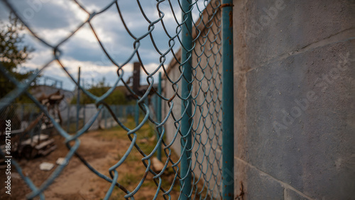 Ground-Level View of Worker Repairing Chain-Link Fence Top Rail