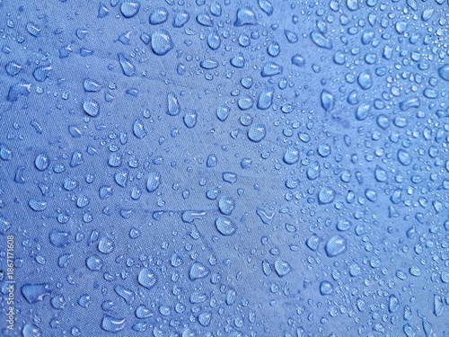Fotografija Water droplets on blue fabric