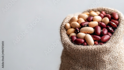 Mixed beans filling a burlap sack, representing healthy nutrition, plant and based sustainable agriculture protein,