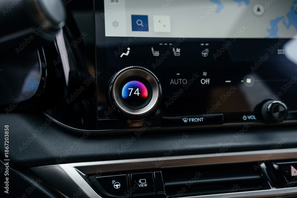 Fototapeta premium A premium, modern brown car interior, leather steering wheel, large navigation screen, air ducts, deflectors on the car panel. Interior details.